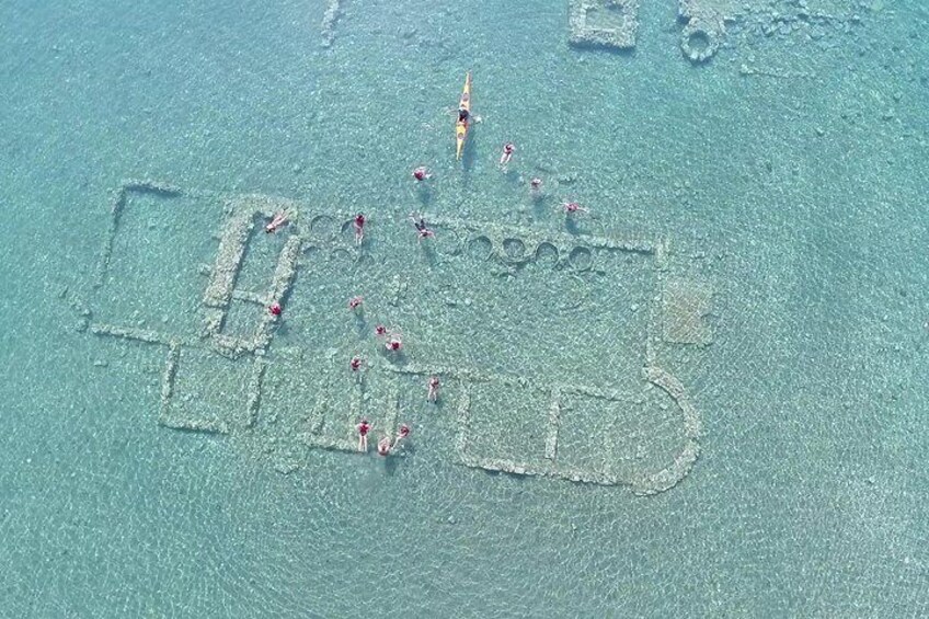 An aerial view of a beach with people swimming and sunbathing. 1
