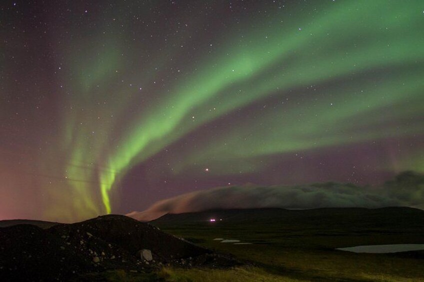 A night sky with the aurora borealis over a mountainous landscape. 2