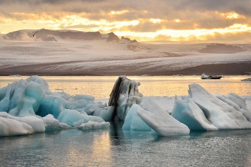 Icebergs in a body of water with a mountainous landscape in the background. 2