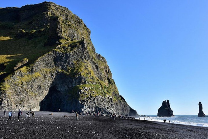 A rocky coastline with a prominent cliff and a large rock formation in the sea. 3