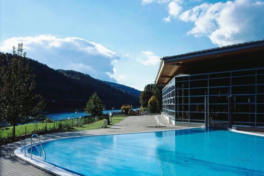 A swimming pool with a view of a lake and mountains in the background. 3