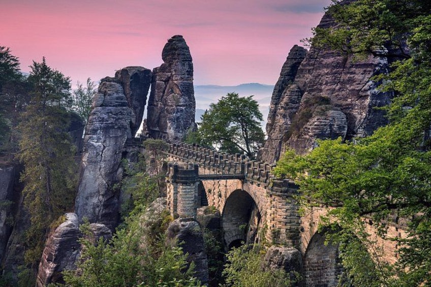 A stone bridge over a gorge with rock formations on either side. 2