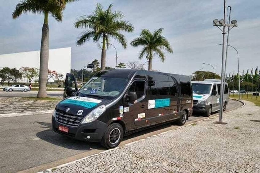 A black van with blue and white markings parked on a street. 3