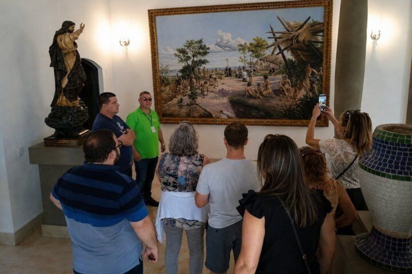 Eine Gruppe von Personen betrachtet ein Gemälde und eine Statue in einer Galerie. 1