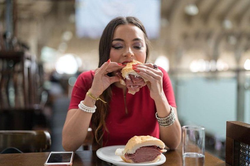 A person eating a sandwich at a table in a restaurant. 2