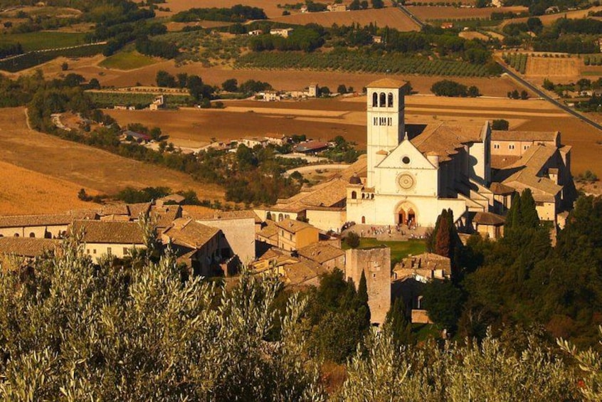 A rural village with a prominent church featuring a bell tower, surrounded by agricultural fields and rolling hills. 2