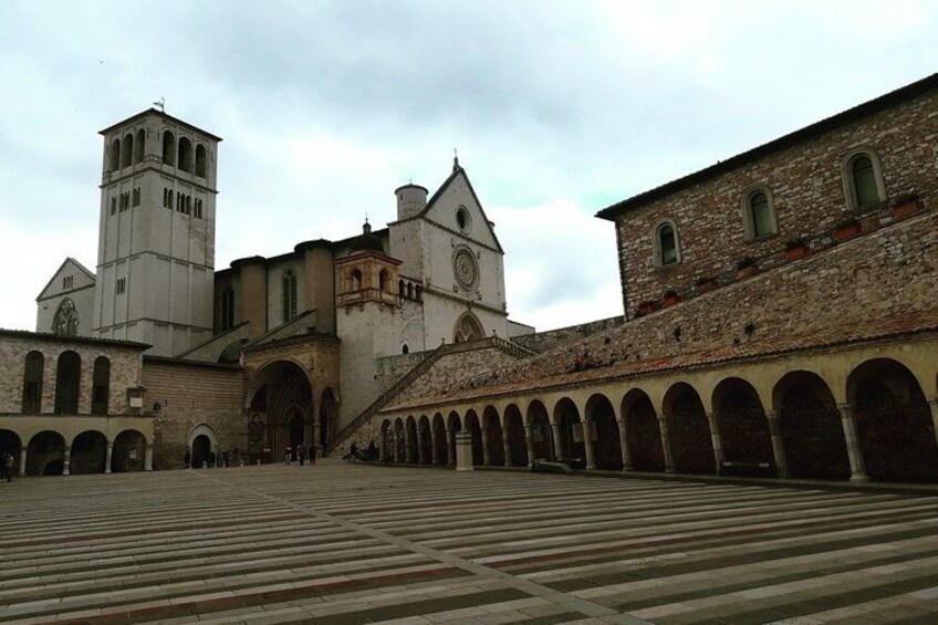 A historic building with a clock tower, arched walkways, and a courtyard. 4