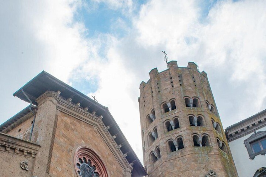 A historic tower with arched windows and a clock. 5