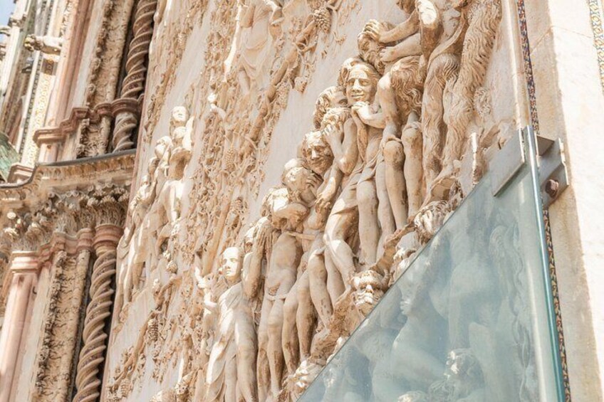 A detailed stone relief with figures and architectural elements. 3