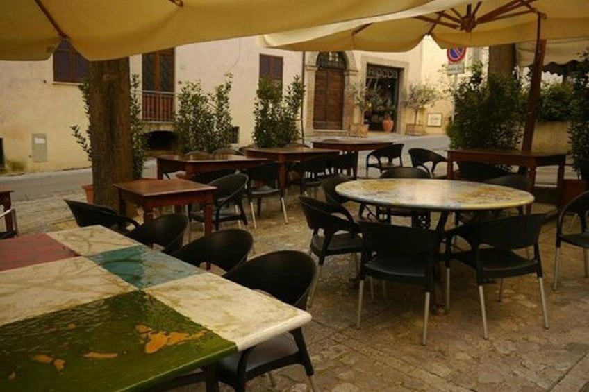 An outdoor café with tables and chairs under umbrellas. 1