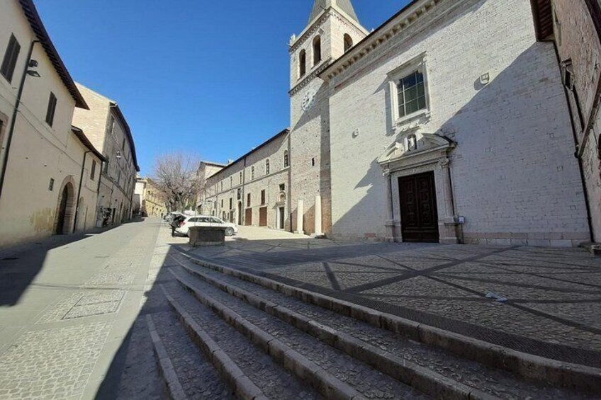 A street with steps leading to a building with a clock tower. 3