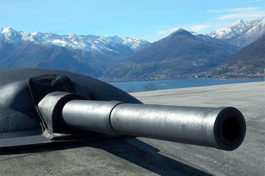 Un objeto cilíndrico metálico de gran tamaño, probablemente una pieza de una aeronave, sobre una plataforma de tarmac con un paisaje montañoso al fondo. 1