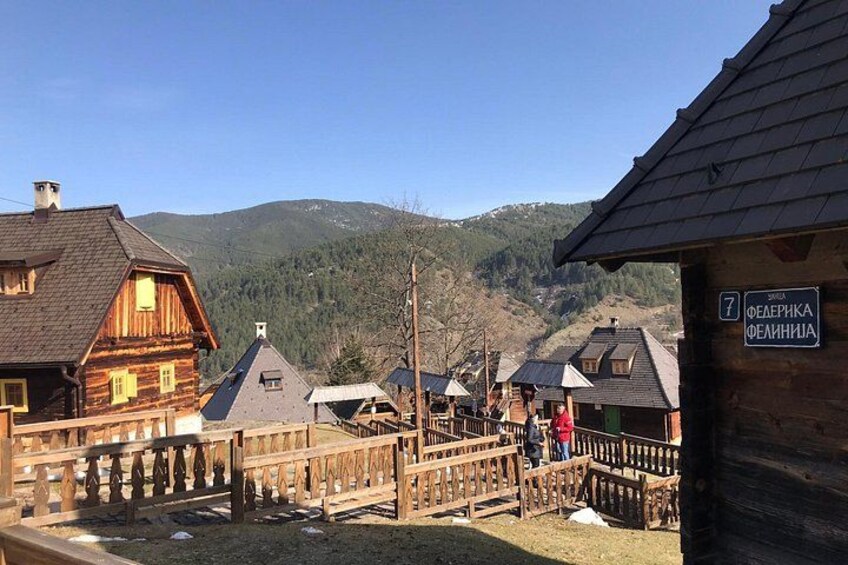 A wooden fence, a wooden building with a sign, and a mountainous landscape in the background. 2