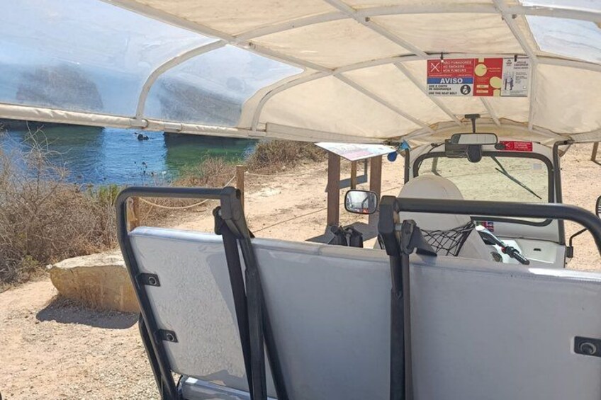 A golf cart with a canopy, parked near a body of water with a sign indicating a waterway. 5