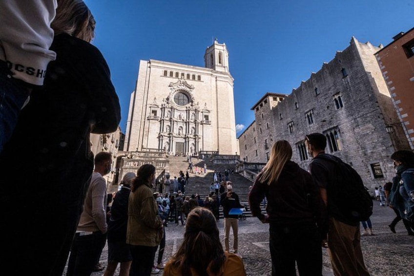 A historic building with a clock tower, a crowd of people, and a cobblestone street. 2