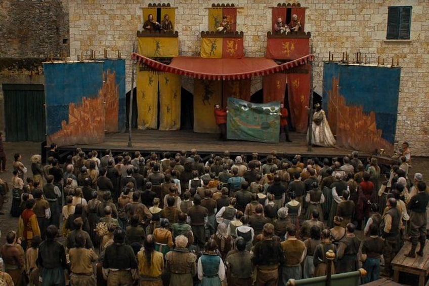 A historical reenactment with a crowd watching a staged battle scene. 5