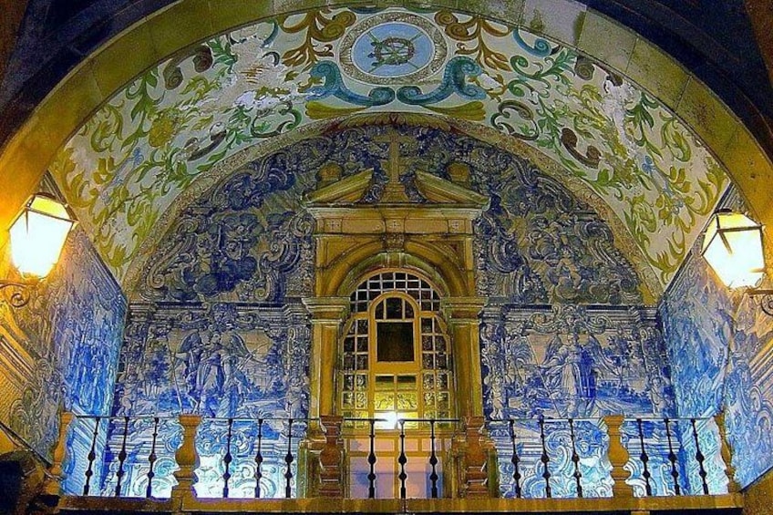Une fresque murale détaillée, ornée de motifs complexes, avec une porte d’entrée centrale en forme d’arc. 4