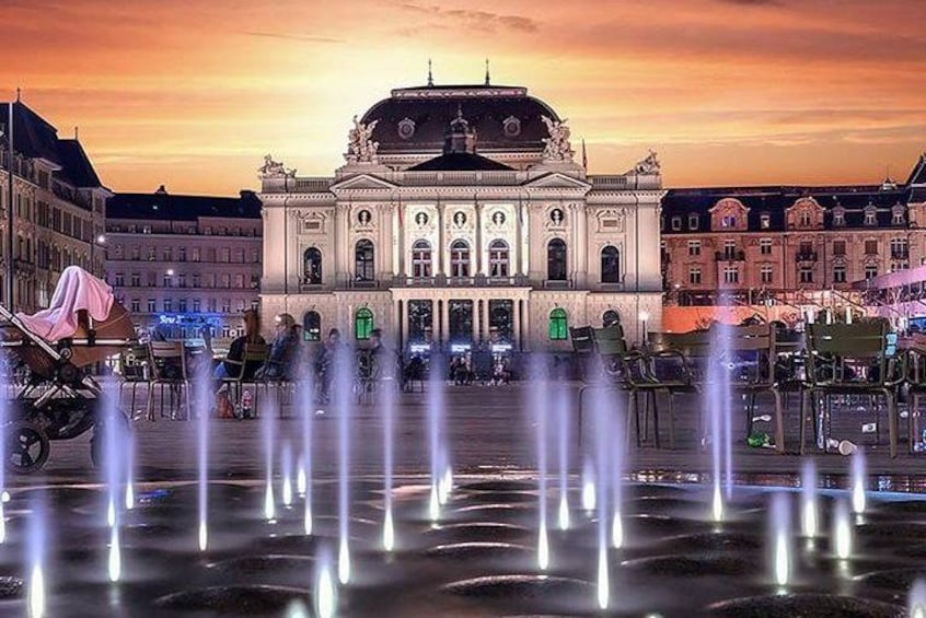 A historic building with a fountain in front. 2
