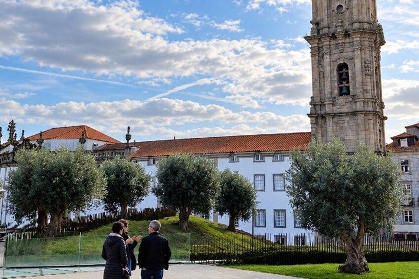 A historic tower, a white building with a red roof, and a grassy area with trees. 2