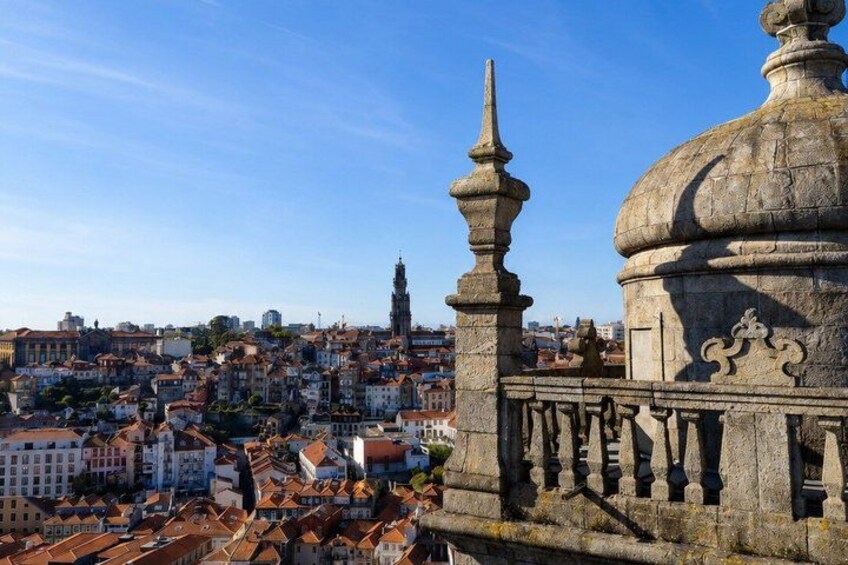 A cityscape with historic buildings, a prominent church steeple, and a decorative stone balustrade. 4