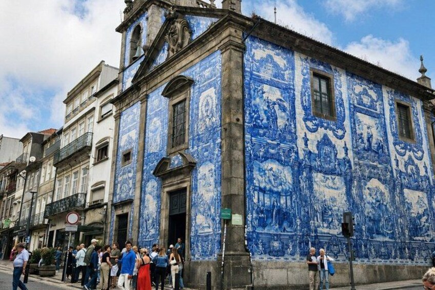 A historic building with blue and white tilework, a street with pedestrians, and a clear sky. 3