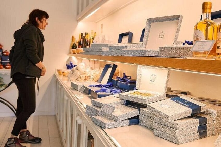 Una persona está de pie frente a un expositor con varios artículos, incluyendo cajas y botellas. 4