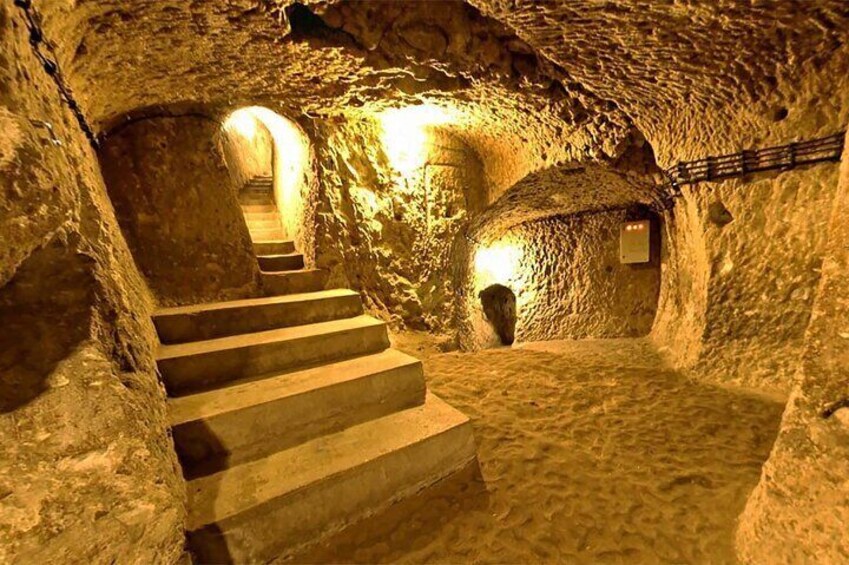 A stone staircase in a cave with natural lighting. 4