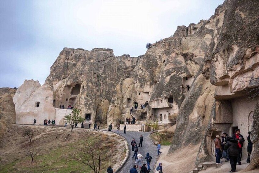 A rock-cut monastery with multiple cave dwellings and a winding path. 2