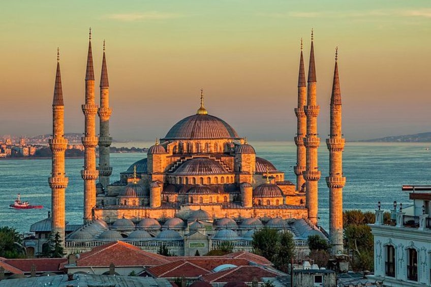 En historisk moské med flera minareter och kupoler, belägen vid en vattenyta. 3