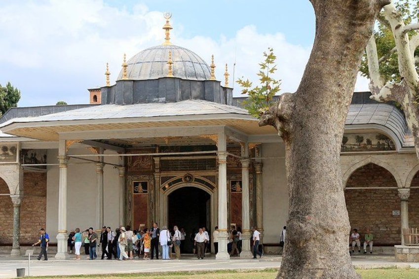 Un edificio storico con una cupola e degli archi, circondato da una folla di persone. 3