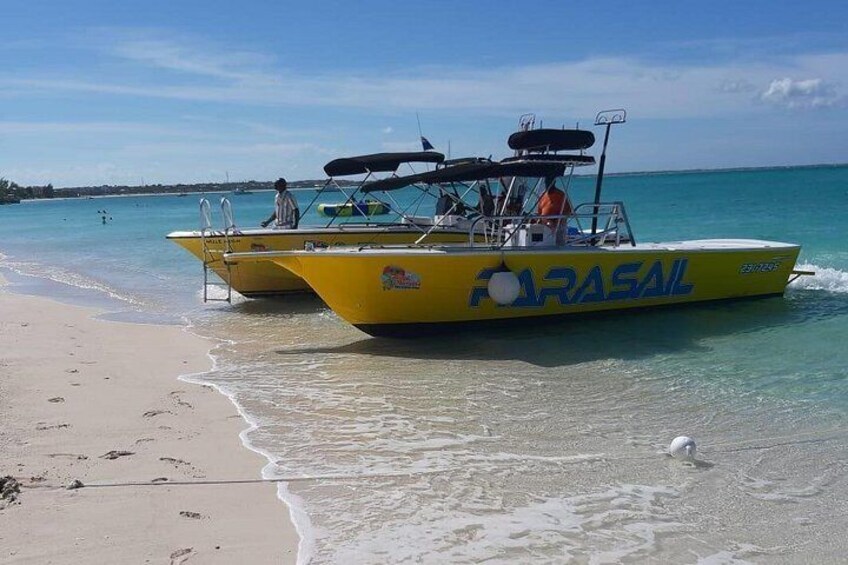 Un bote amarillo llamado 'FARASAIL' en una playa con agua turquesa cristalina. 4