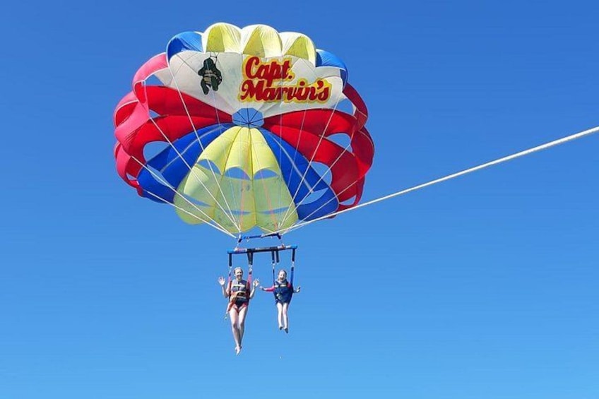 A parachute with the text 'Capt. Marvin's' attached to it, with two people in mid-air. 3