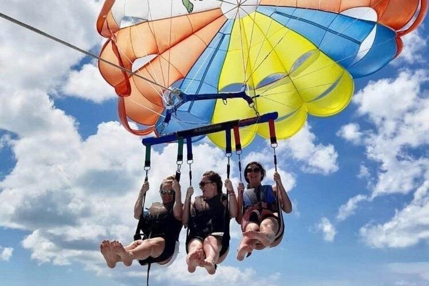 Three people suspended in the air by a parachute. 5