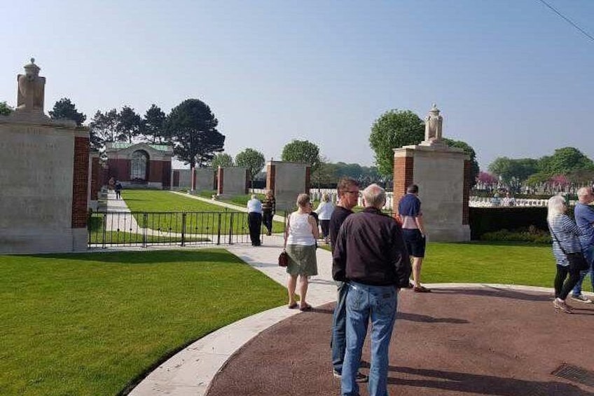A cemetery with headstones, a brick building, and a statue. 1