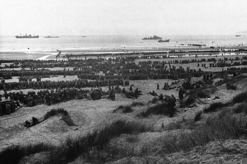 A coastal landscape with dunes, a beach, and ships in the distance. 1