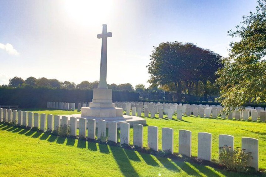 A cemetery with a prominent cross monument surrounded by rows of headstones. 2