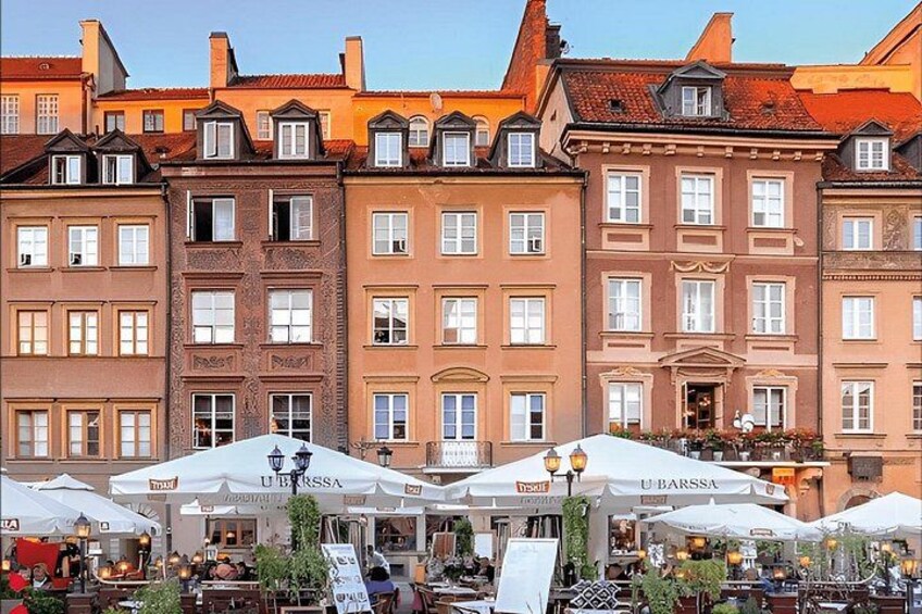 A row of historic buildings with outdoor cafes and umbrellas. 4