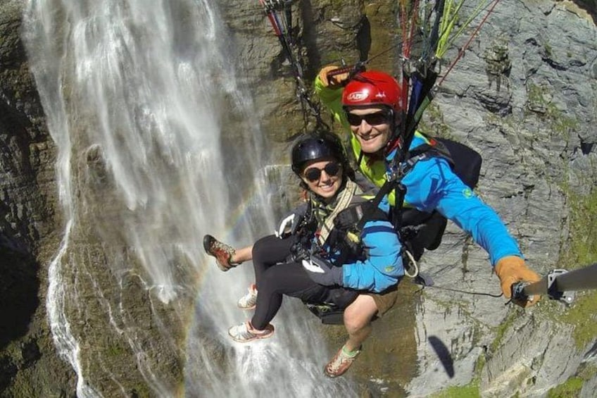 Two people rappelling down a waterfall. 3
