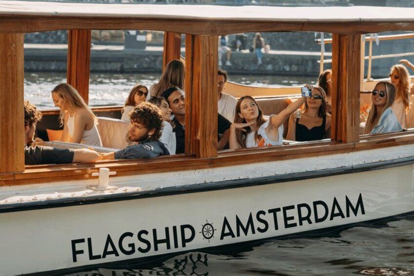 A boat with people on board, named 'FLAGSHIP AMSTERDAM.' 2