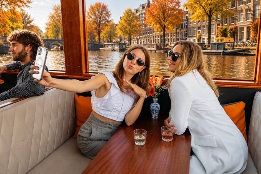 A boat with people taking a selfie, a wooden table, and a cityscape with autumn trees. 4