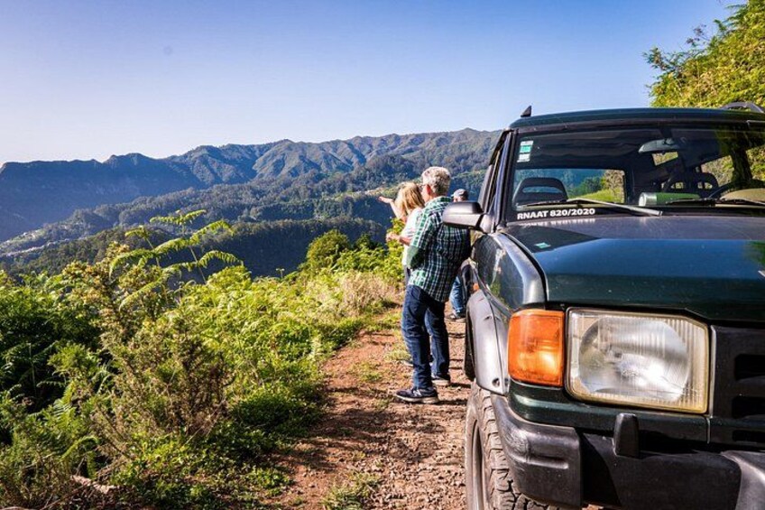 Un vehículo estacionado en un camino de tierra con un paisaje montañoso al fondo. 2