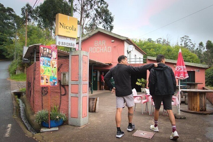 Un bar llamado 'Bar Rochão' con un letrero que anuncia 'Nicola snacks' y un cartel llamativo. 5