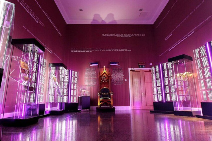 A modern interior with illuminated panels, a central decorative element, and text on the walls. 2