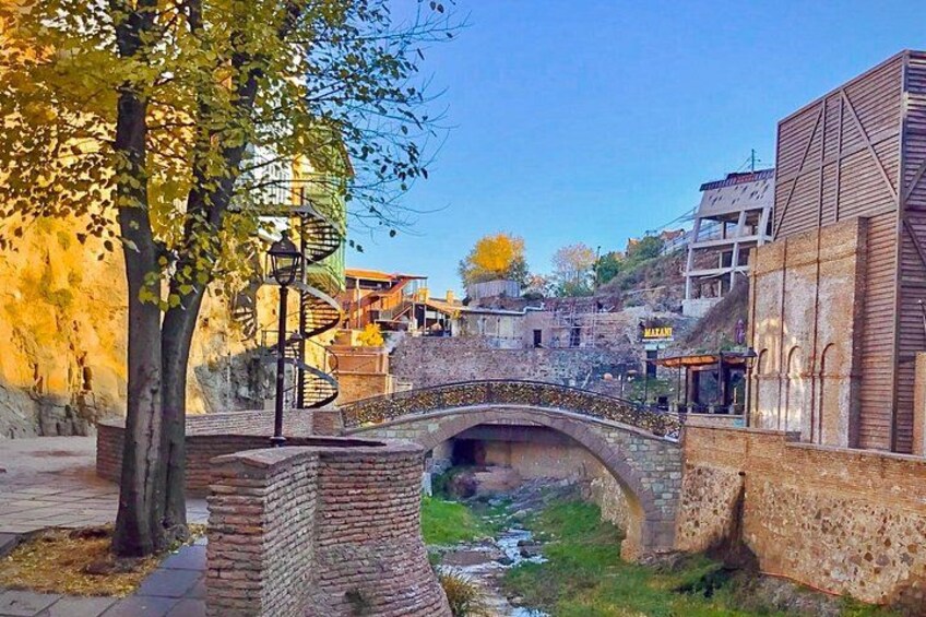 Un pont de pierre enjambant une rivière, entouré d’arbres et de bâtiments. 2