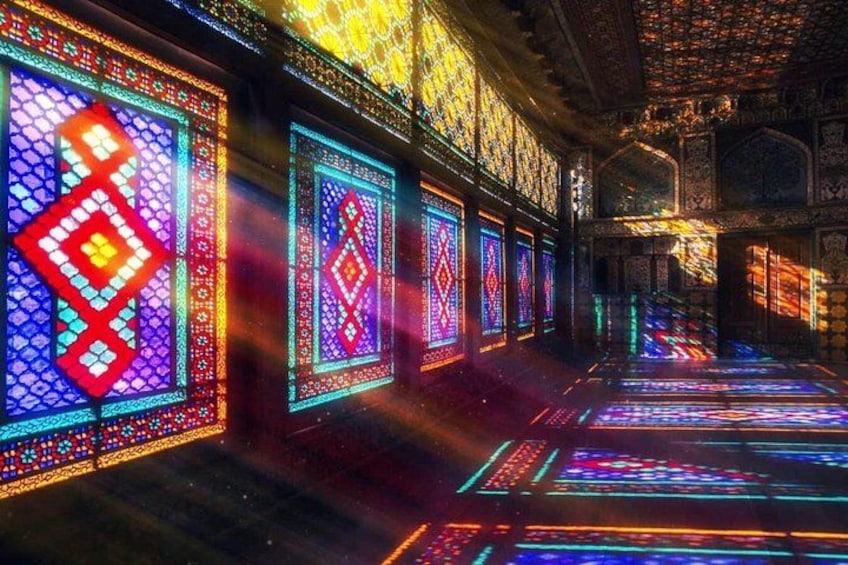 A corridor with colorful stained glass windows and intricate architectural details. 1
