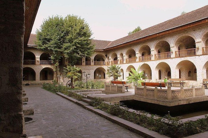 A courtyard with arches, benches, and a central water feature. 2