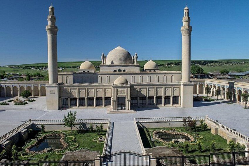 Una gran mezquita con dos altos minaretes, una cúpula central y un patio con diseños de jardín geométricos. 2
