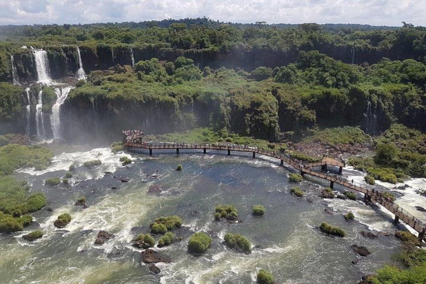 A river with rapids, a bridge, and a waterfall in a forested area. 3