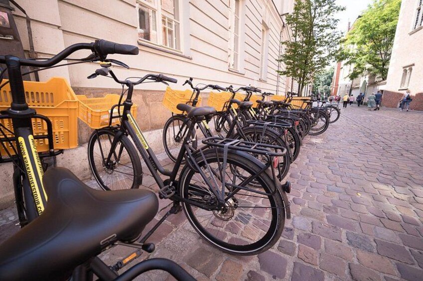 A row of bicycles parked on a cobblestone street. 5