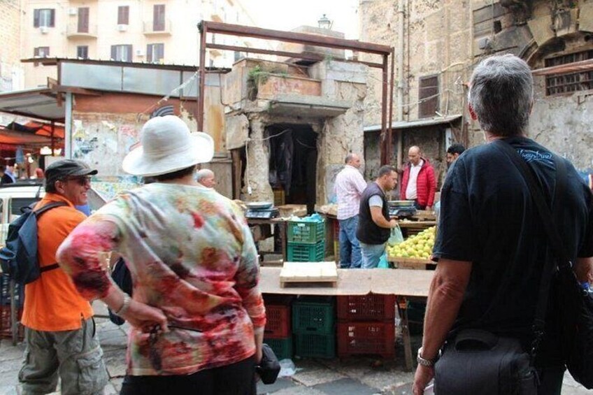 A street market with people shopping and vendors selling goods. 1
